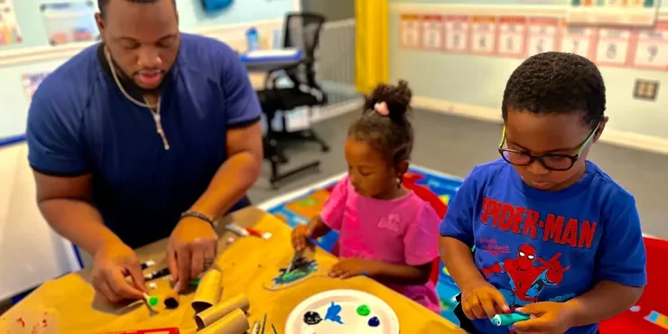 Teacher helping children create an art project