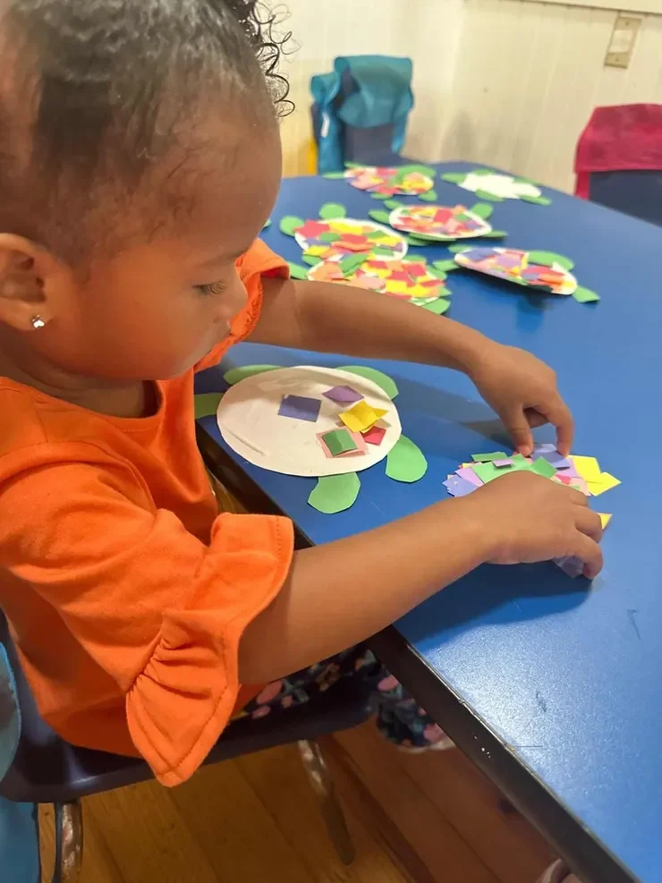 Child creating a colorful paper craft