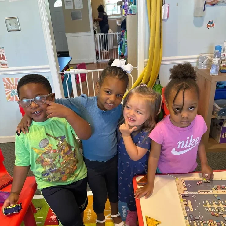 A group of children smiling together inside Monumental Kids Academy