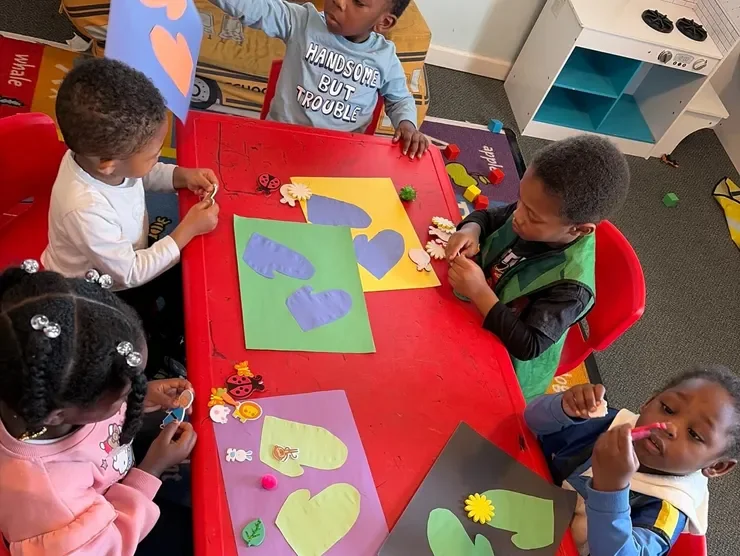 Children working together on a colorful classroom craft